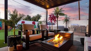 An outdoor patio with a fire feature, seating, and a grill area. - Ultimate Getaway, Pool, Hot Tub & Mini Golf (Tempe)