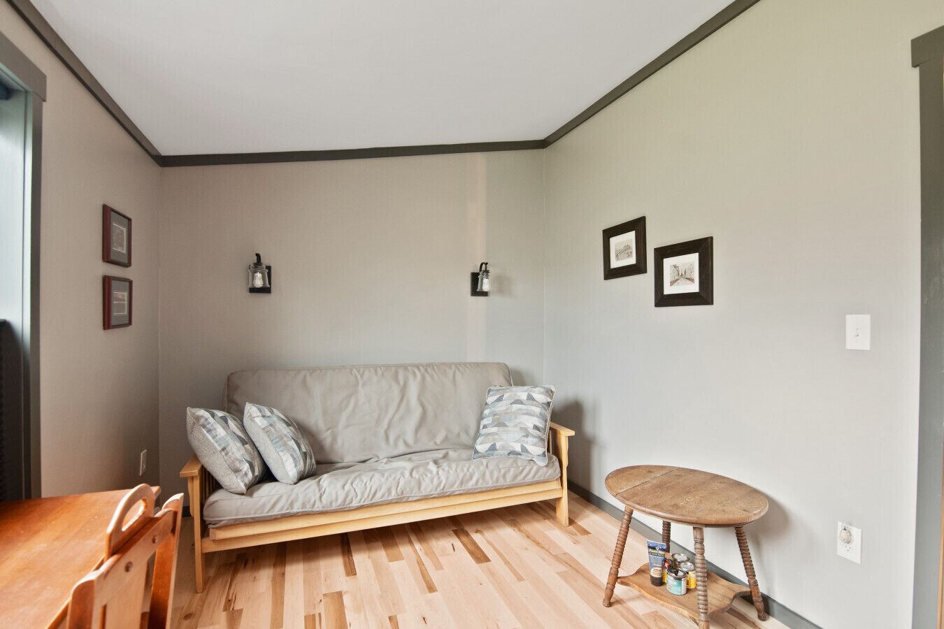 Un salon chaleureux avec un canapé, une table basse en bois et une petite table d’appoint.
