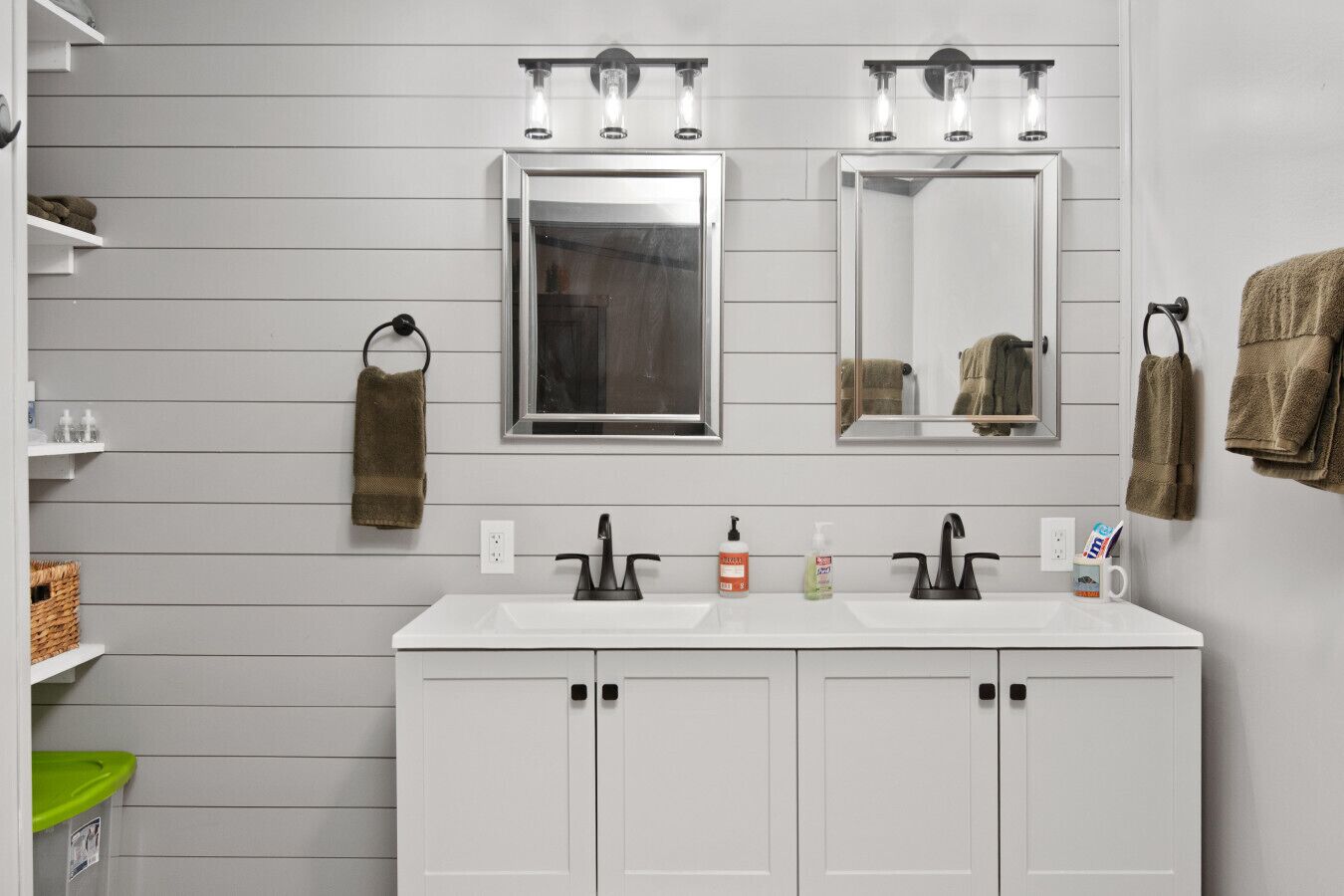 A bathroom with two sinks, a mirror, and overhead lighting.