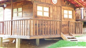 A wooden cabin with a balcony, large windows, and a red roof. - OTRO ROLLO EN JILOTPEC ZACAPOAXTLA  (Zacapoaxtla)