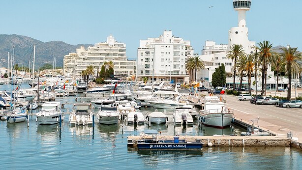 A marina with numerous boats docked, a prominent white lighthouse, and modern buildings in the background. - WELCS APARTAMENTO 260 EMP con vistas al canal (Empuriabrava)