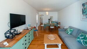 A living room with a television, wooden coffee table, and a sofa with green cushions. - WELCS APARTAMENTO 260 EMP con vistas al canal (Empuriabrava)