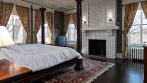 A bedroom with a large bed, a fireplace, and a view of the outdoors. - Spacious 6-bedroom house with AC, WiFi in charming Springfield (Springfield)