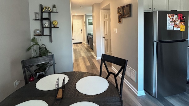 A modern kitchen with a built-in refrigerator, a dining table with placemats, and a ceiling fan.