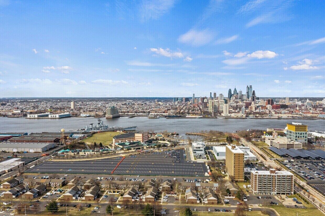 Une vue urbaine comprenant une rivière, une zone industrielle et un parking.