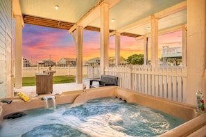 A hot tub with a view of a sunset, a wooden deck, and a fence. - Ocean View | Hot tub | Game Loft | Walk to beach l Pickleball (Port Bolivar)