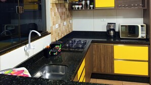 A kitchen with a gas stove, a microwave, and a coffee maker. - Big House Leisure 🌊 (Dourados)
