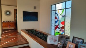 Eine Treppe mit Holzhandlauf, einem an der Wand befestigten Spiegel und einem Bilderrahmen mit einem abstrakten Gemälde.