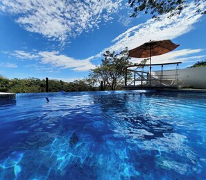 A clear blue pool with a wooden deck and a canopy. - Wonderful Chalet on Exclusive Golf Course (Colima)