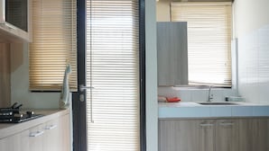 Eine moderne Küche mit Holzausstattung, einem Spülbecken und einem Fenster mit Jalousien.