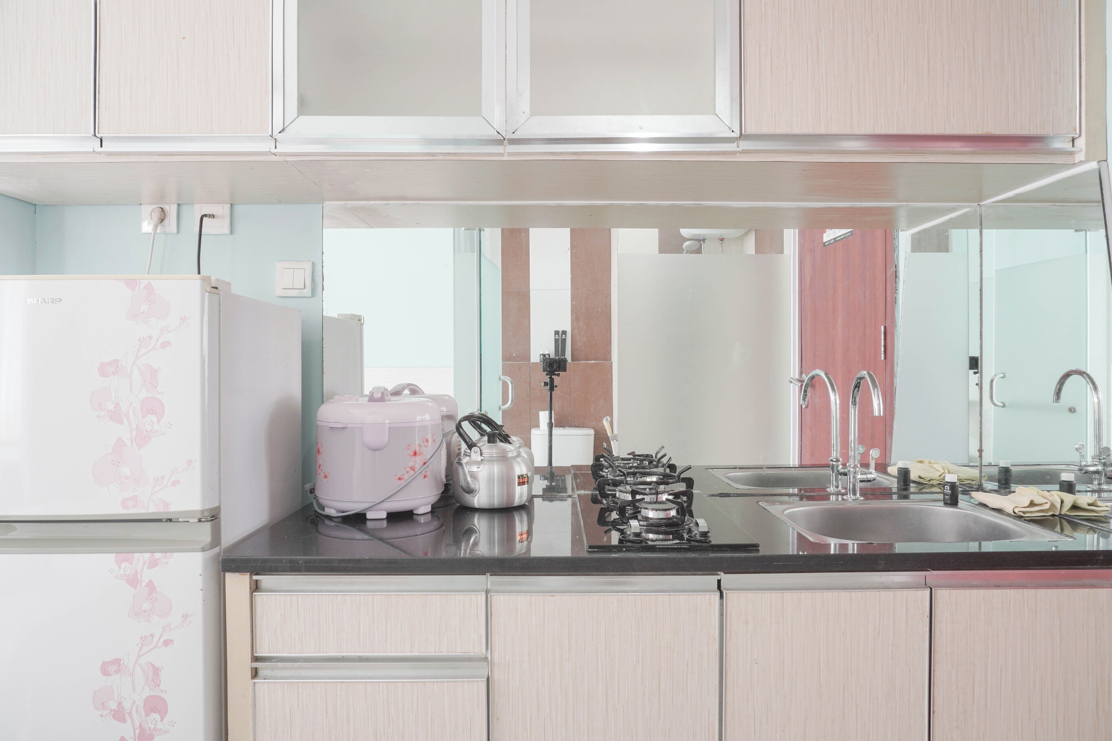 A kitchen with light-colored cabinets, a refrigerator, a gas stove, and a sink.