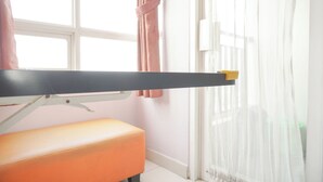 A room with a bed, a window with curtains, and a bedside table. - Homey And Nice Studio Cinere Bellevue Suites Apartment (Depok)