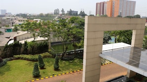 Un patio con un elemento acuático central, rodeado de setos y árboles bien cuidados.