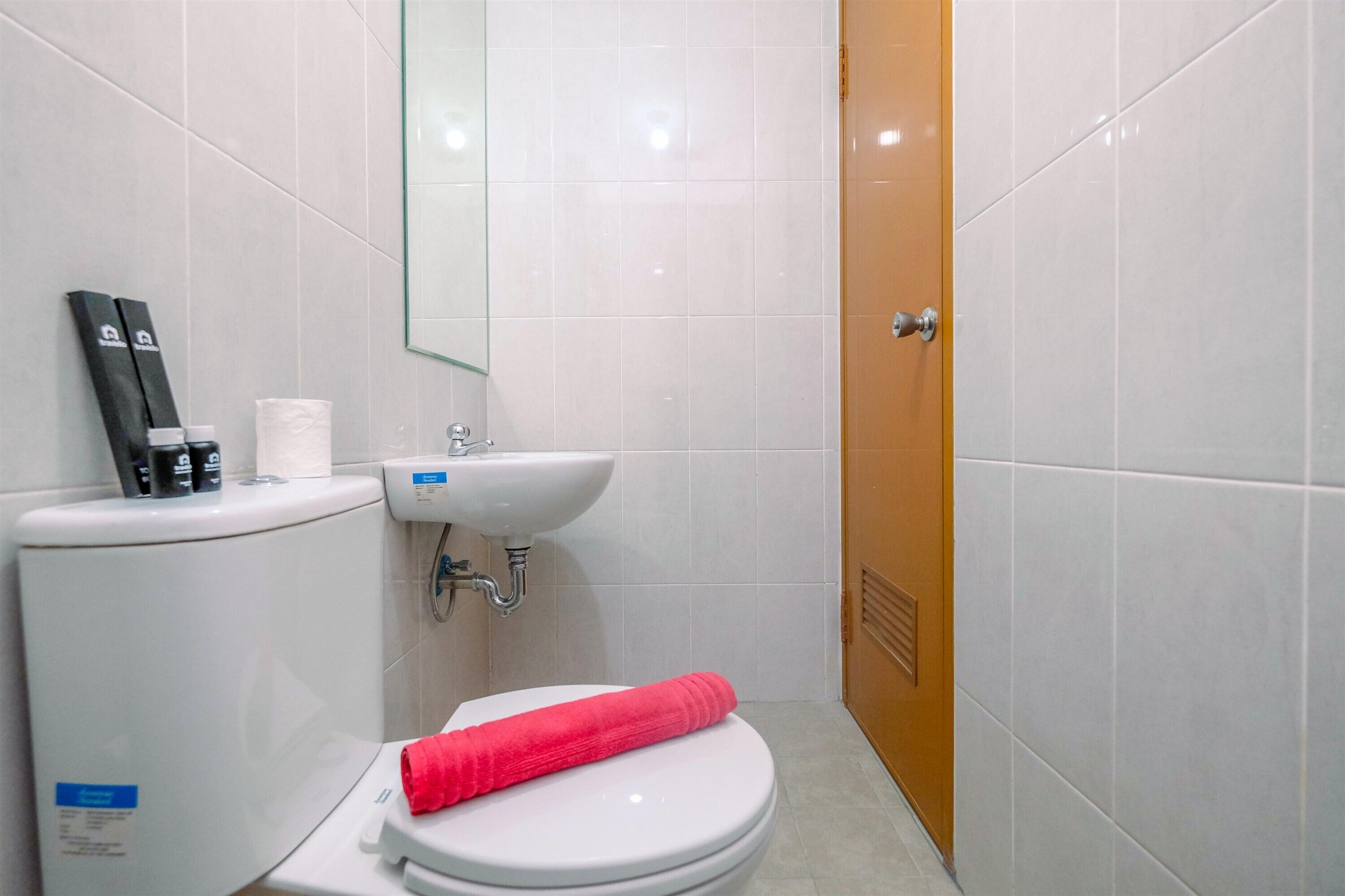 A bathroom with a toilet, a sink, and a mirror.