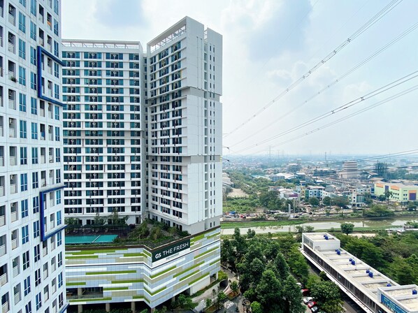 Un immeuble moderne de grande hauteur, doté de nombreux étages, de grandes fenêtres et d’un jardin sur le toit.