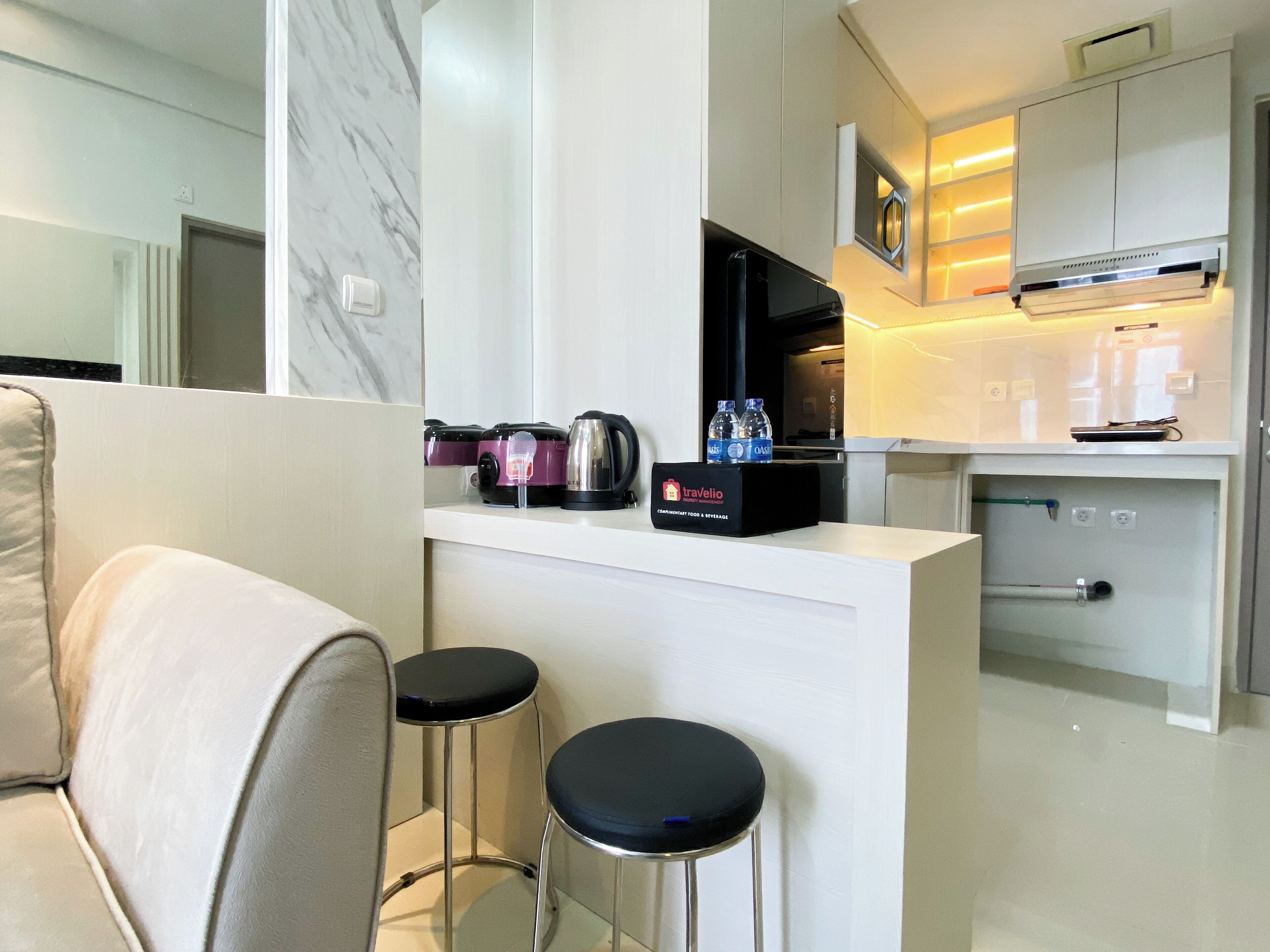 A modern kitchen with a marble backsplash, a coffee machine, kettles, and a minibar.