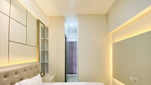 Ein Hotelzimmer mit einem großen Bett, einem eingebauten Kleiderschrank und einem Spiegel.