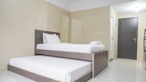 Une chambre d’hôtel moderne avec un lit double, une tête de lit en bois et un sol carrelé, propre et bien entretenu.