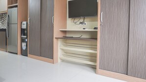 Une cuisine moderne dotée d’appareils électroménagers intégrés, d’un téléviseur à écran plat et d’une machine à café.