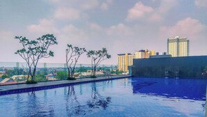A rooftop swimming pool with a view of a cityscape. - Cozy Studio At 32Th Floor Evenciio Margonda Apartment (Depok)