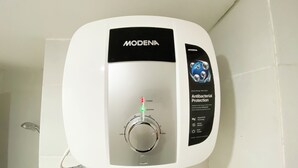 A white electric water heater with a control panel, labeled 'MODENA', featuring 'Antibacterial Protection' and 'MagnHealth Technology'. - Well Furnished And Cozy Studio Paltrow City Apartment (Semarang)