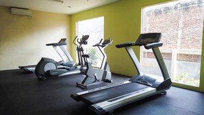 A gym with treadmills, ellipticals, and a stationary bike. - Good Deal And Restful Studio Tamansari Sudirman Apartment (Jakarta)