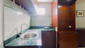 A compact kitchen with a sink, cabinets, and a window. - Good Deal And Restful Studio Tamansari Sudirman Apartment (Jakarta)