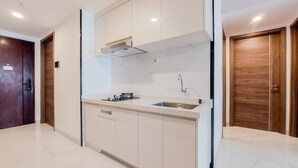 A modern kitchen with white cabinetry, a stainless steel sink, and a built-in oven.