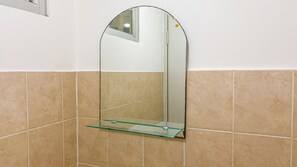 A bathroom with a glass shelf mounted on a wall above a tiled floor. - Best Deal And Strategic 2Br At Green Bay Pluit Apartment (Jakarta)