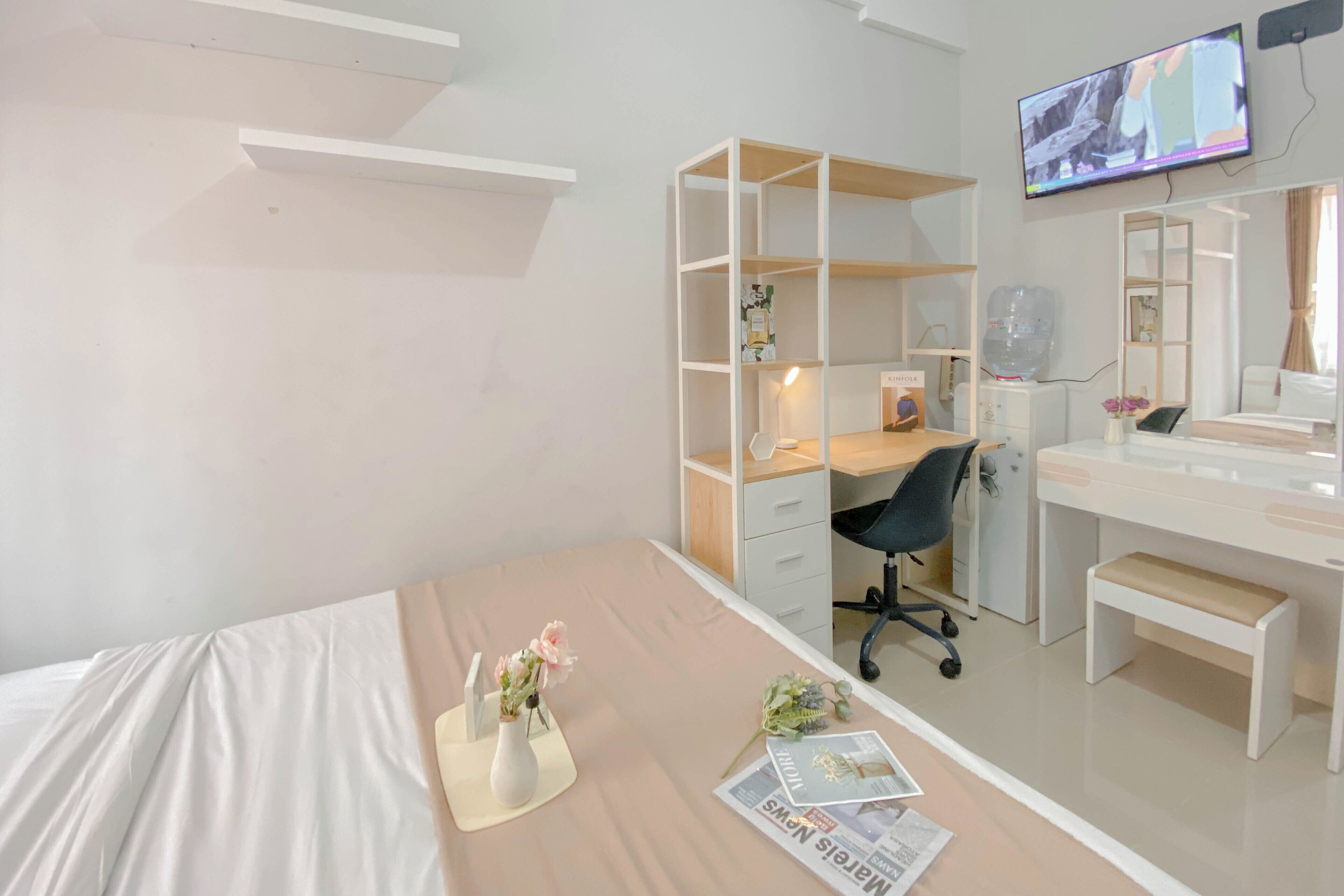 Una camera da letto moderna con un letto, una scrivania e una TV.