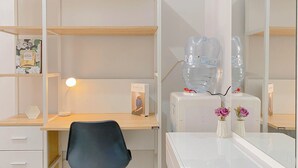 A modern office space with a desk, chair, shelves, and a large mirror. - Good And Warm Studio Transpark Juanda Bekasi Timur Apartment (Bekasi)