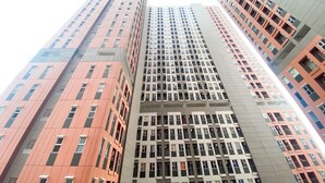 A high-rise building with multiple floors, featuring a mix of architectural styles and window patterns. - Good And Warm Studio Transpark Juanda Bekasi Timur Apartment (Bekasi)