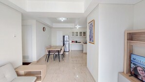 A modern apartment with a dining area, kitchen, and living space. - Serene And Comfort Living 3Br At Podomoro City Deli Medan Apartment (Medan)