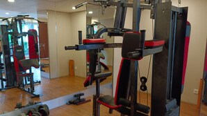 A gym with various exercise equipment, including dumbbells and weight machines. - Comfortable And Homey Studio Room Parkland Avenue Apartment (South Tangerang)