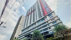 A high-rise building with multiple floors, balconies, and a mix of architectural styles. - Comfortable And Homey Studio Room Parkland Avenue Apartment (South Tangerang)