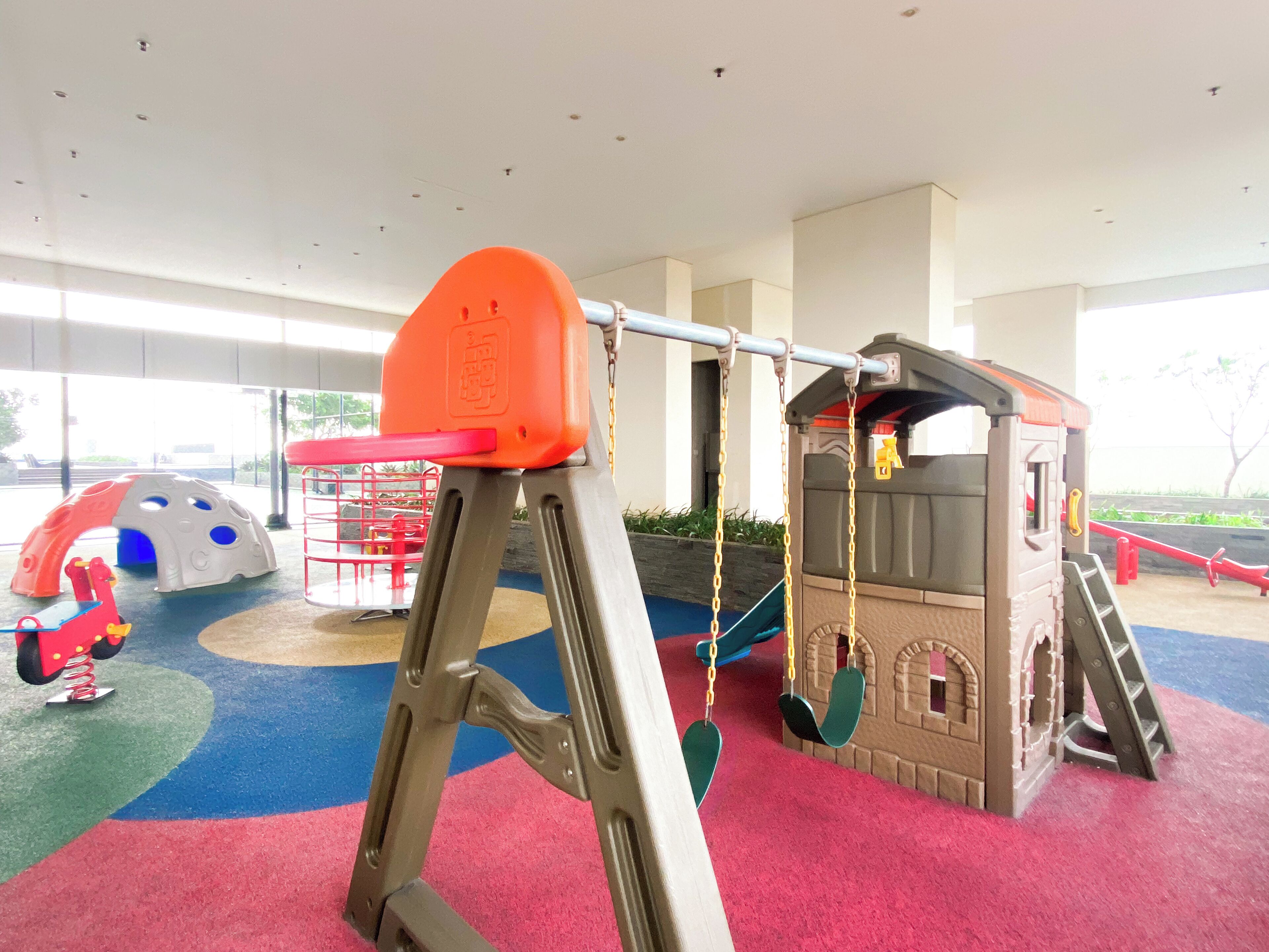 A children's play area with a swing set, a climbing structure, and a slide.