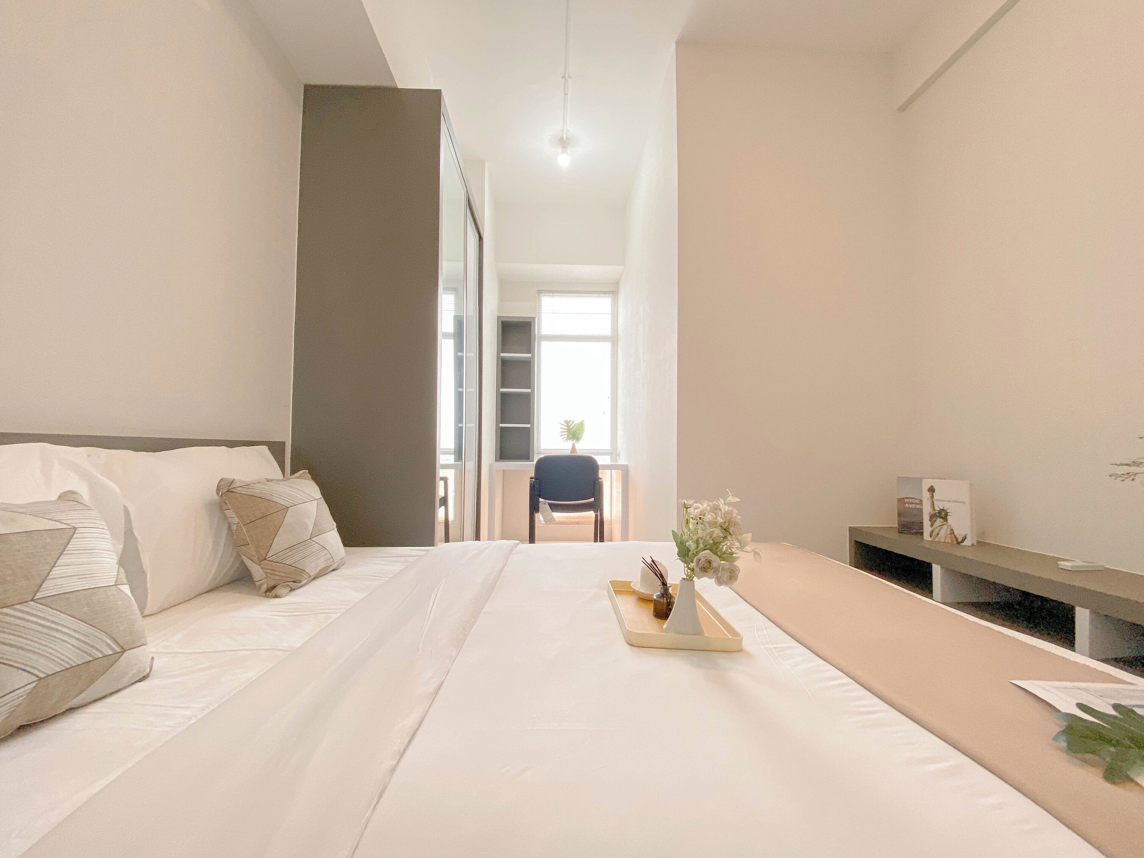 A modern hotel room with a large bed, a desk, and a chair.