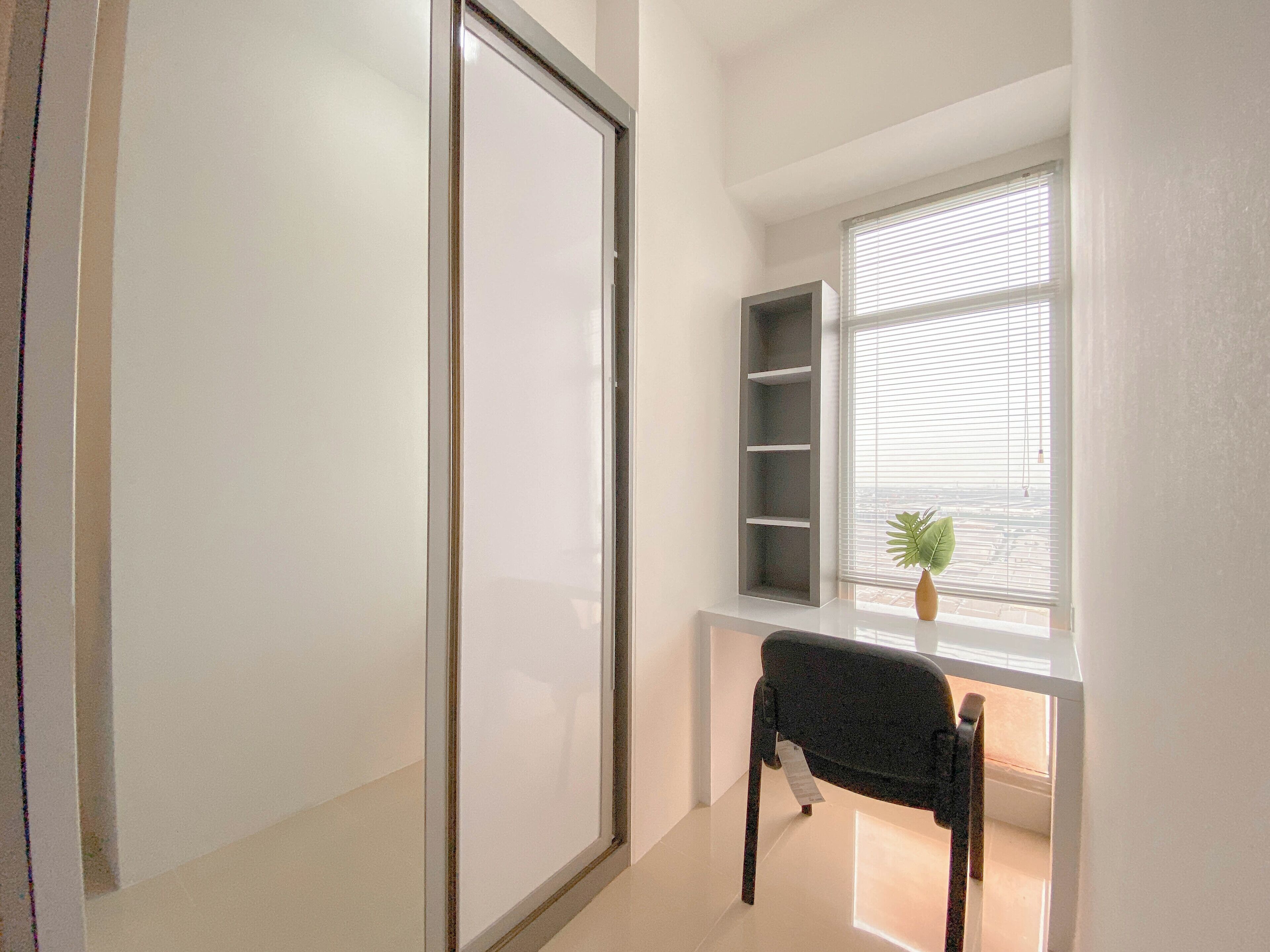 A room with a sliding door, a window with blinds, a shelf unit, and a chair.
