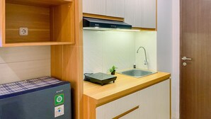 A compact kitchen with a built-in dishwasher, a sink, and a compact refrigerator. - Cozy And Enjoy Living Studio Transpark Juanda Bekasi Timur Apartment (Bekasi)