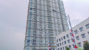 A tall, multi-story building with numerous windows and balconies. - Good Choice Studio Apartment Tamansari Mahogany Karawang (Karawang)