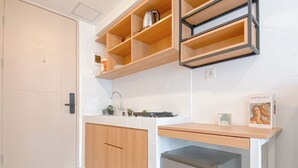 A compact kitchen with a wooden countertop, a sink, and a small refrigerator. - Warm And Good Studio Room At Tokyo Riverside Pik 2 Apartment (Teluknaga)