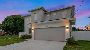A modern two-story house with a garage, numbered 3105, and a well-maintained lawn.