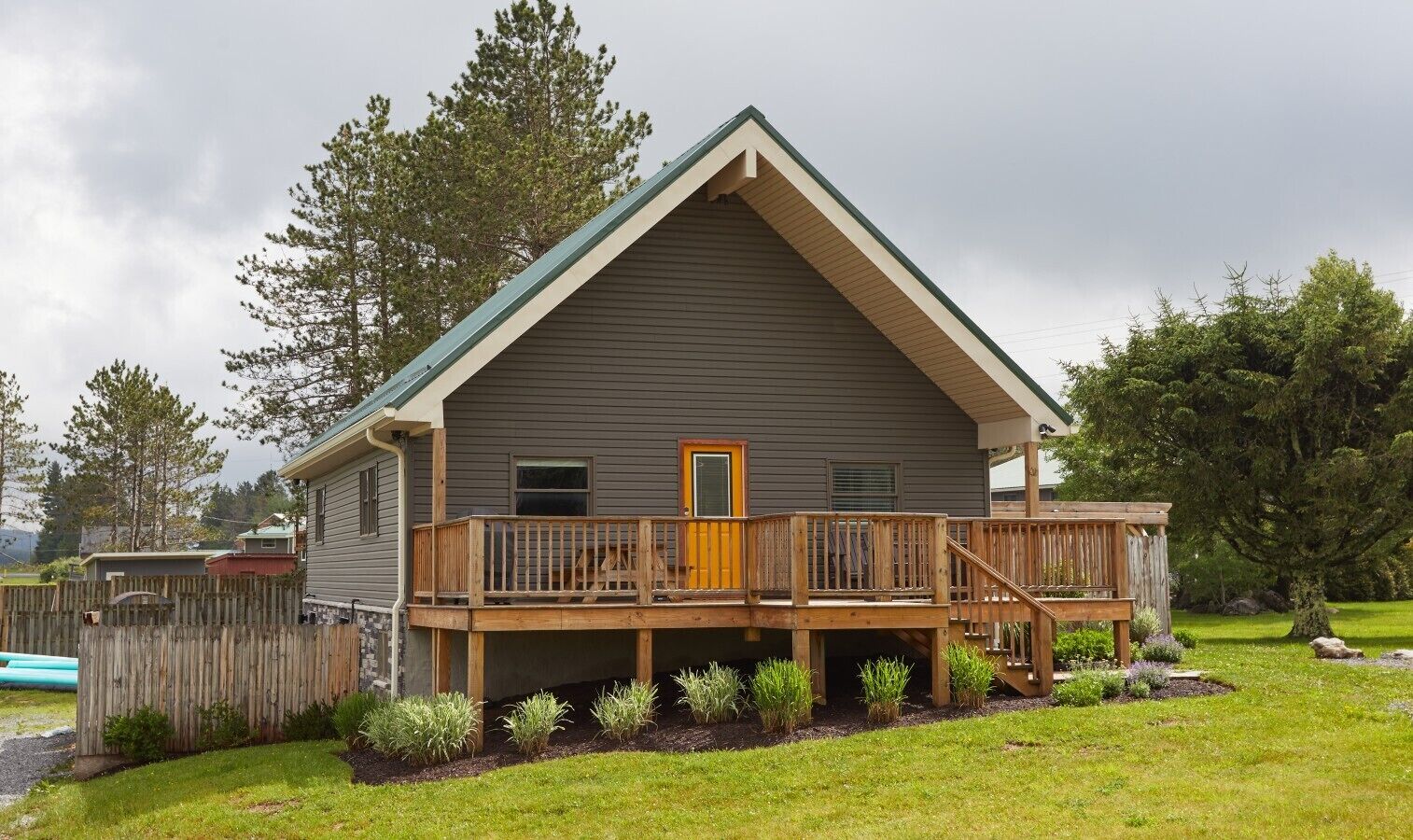 A two-story house with a wooden deck and a front porch.