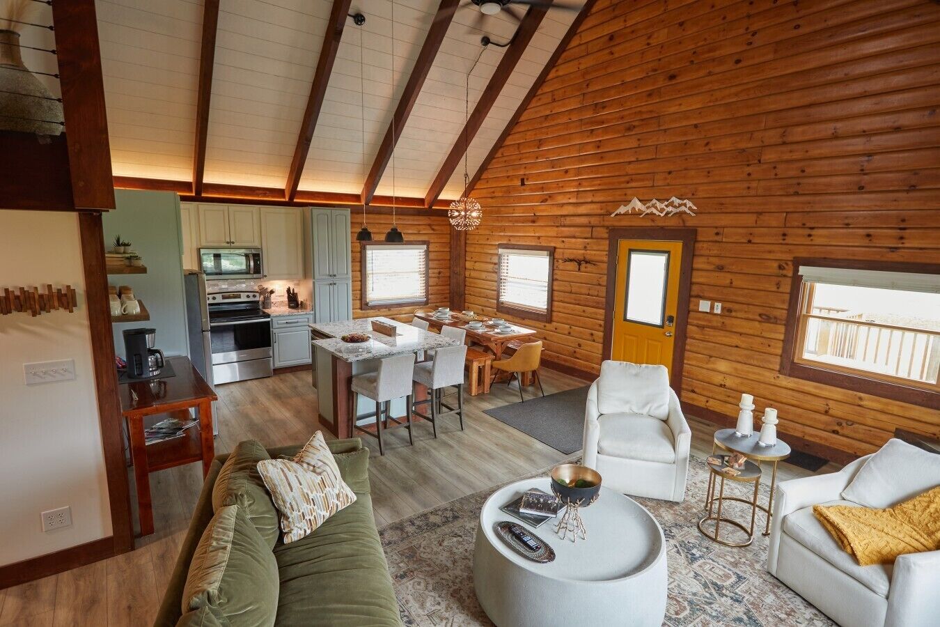 A cozy cabin interior with a dining area, kitchen, and seating space.