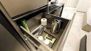 A kitchen drawer with a kettle, a bottle, a roll of toilet paper, and a coffee maker. - Chungju Browndot Cityhall (Chungju)