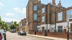 A row of terraced houses with brick facades and white-painted lower sections. - Super 2BD Maisonette in Queens Park, Maida Vale (London)