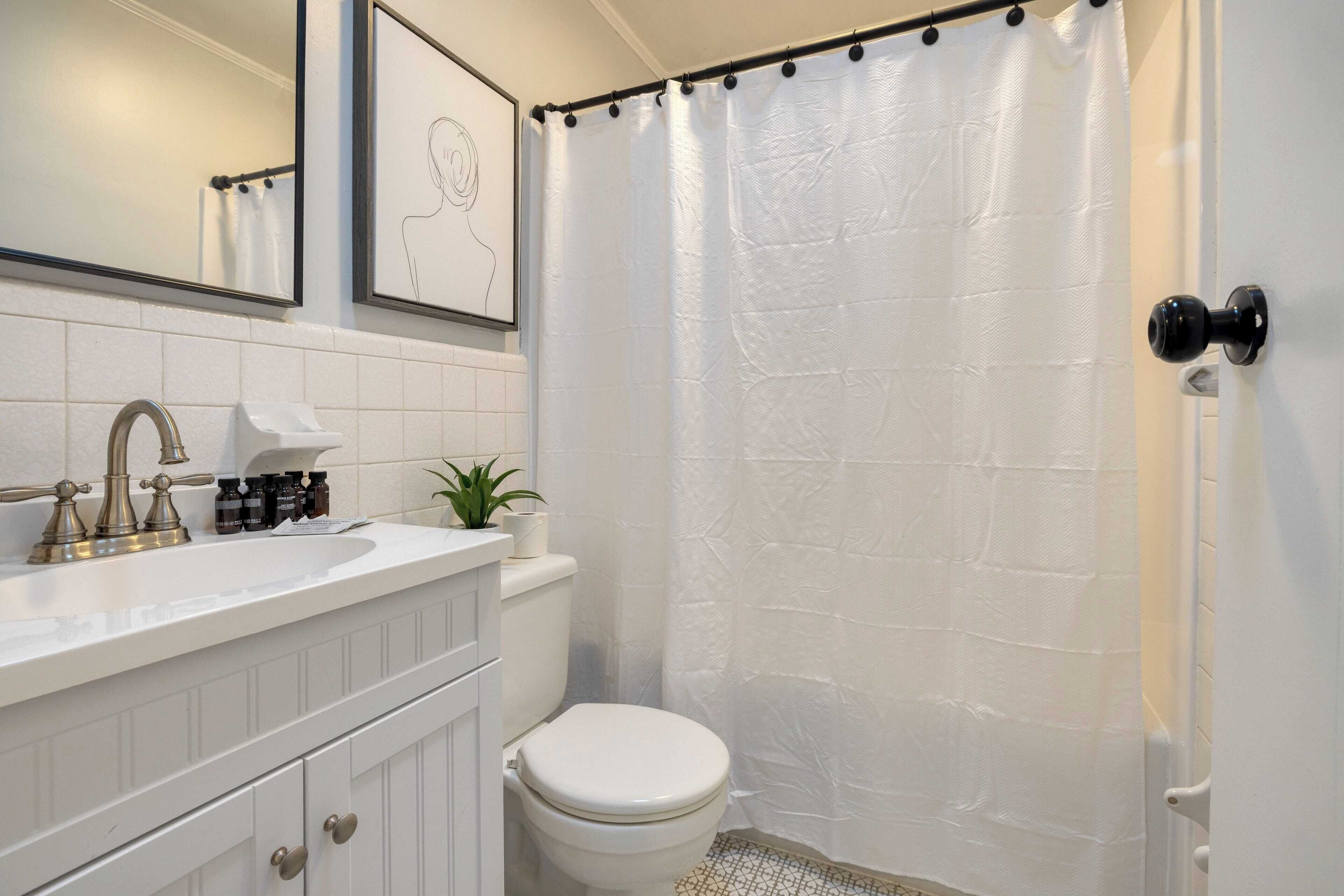 A bathroom with a white sink, a toilet, and a shower curtain.
