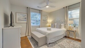 A bedroom with a bed, bedside tables, a TV, and artwork on the walls. - The Powder Cottage by Avantstay Heart of Old Mt. Pleasant Near Sullivans (Mount Pleasant)