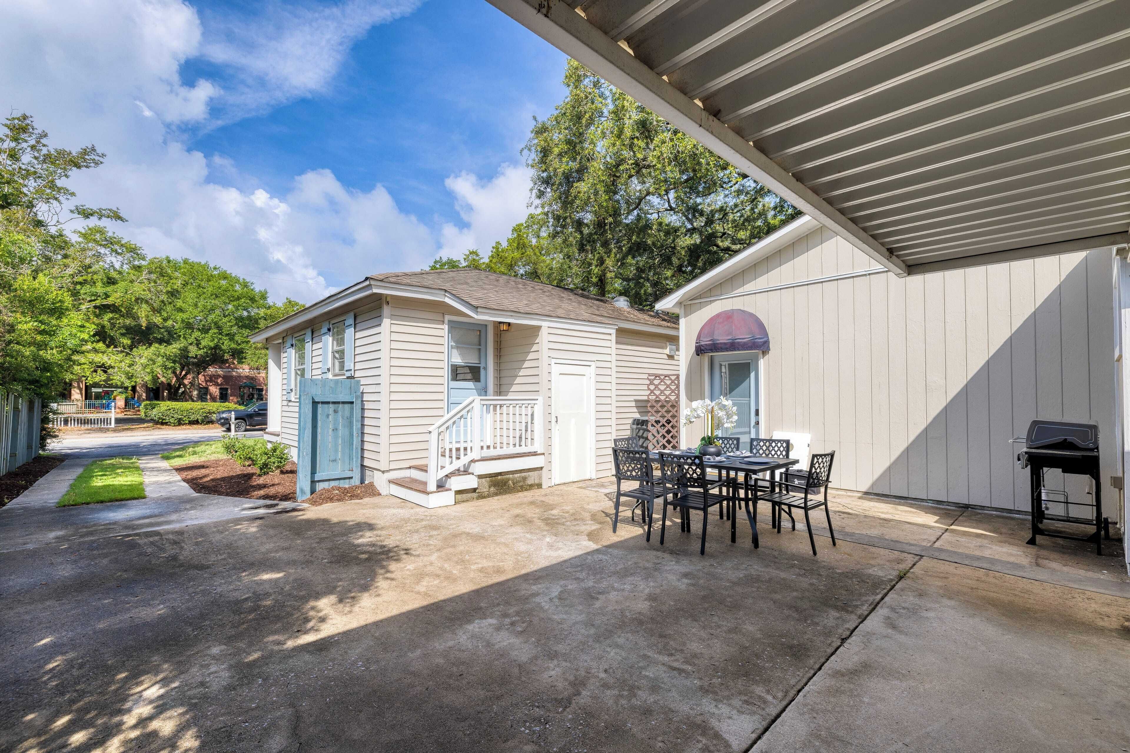 A residential property with a covered patio, a dining area with outdoor furniture, and a garage.