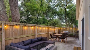 An outdoor patio with a sectional sofa, a table, and chairs. - The Cannon Cottage by Avantstay Old Mt. Pleasant Gem Near Sullivans Island (Mount Pleasant)